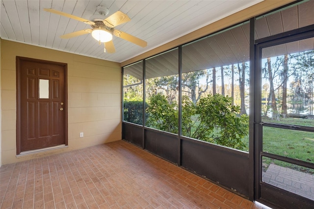 unfurnished sunroom featuring a wealth of natural light and ceiling fan