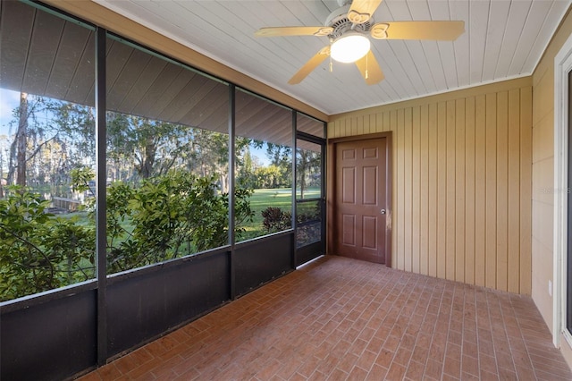 unfurnished sunroom featuring ceiling fan