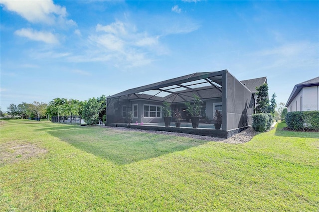 back of house with glass enclosure and a yard