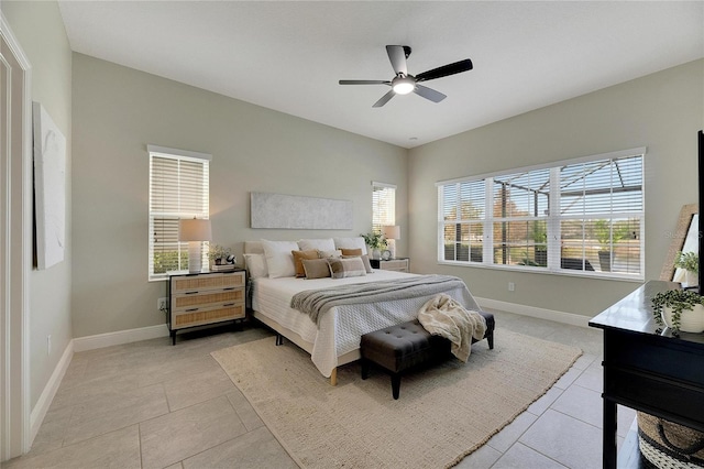 tiled bedroom with ceiling fan and multiple windows