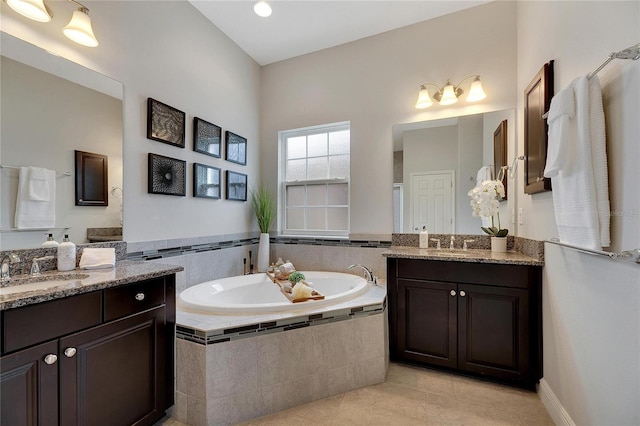 bathroom featuring tile patterned floors, vanity, and a relaxing tiled tub