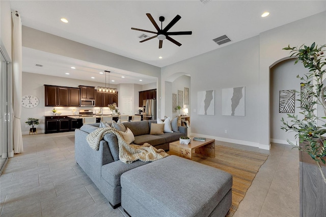 living room with ceiling fan with notable chandelier