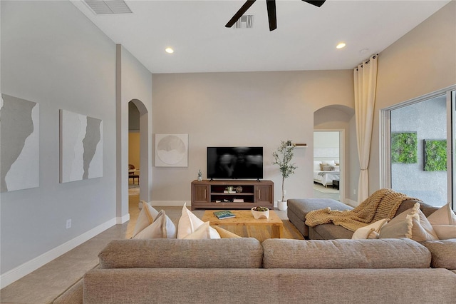 living room featuring ceiling fan and a high ceiling