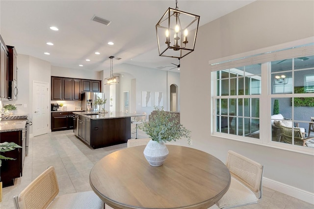 tiled dining space with a chandelier