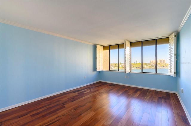 spare room featuring dark hardwood / wood-style floors and ornamental molding