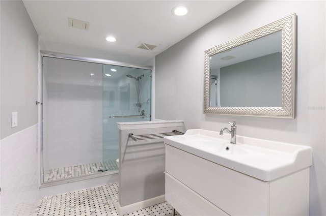 bathroom featuring vanity and a shower with shower door