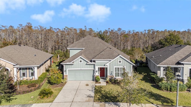 view of front of home featuring board and batten siding, roof with shingles, driveway, and a front lawn