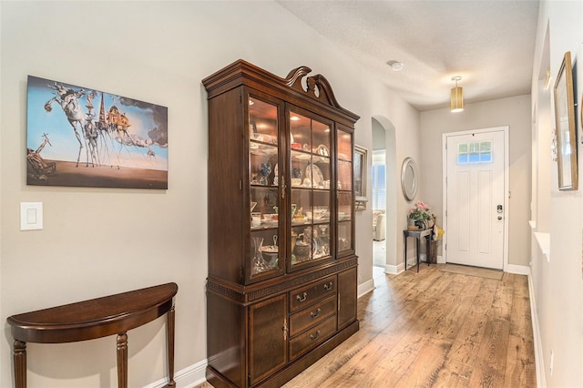 foyer entrance with a textured ceiling and light hardwood / wood-style floors