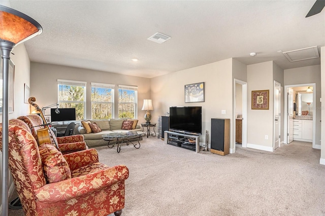 living room featuring a textured ceiling, carpet, visible vents, and baseboards