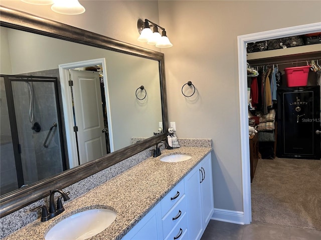 bathroom with a stall shower, a sink, a spacious closet, and double vanity