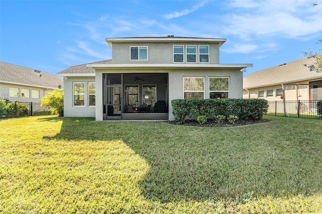 rear view of house featuring a yard, fence private yard, a sunroom, and stucco siding