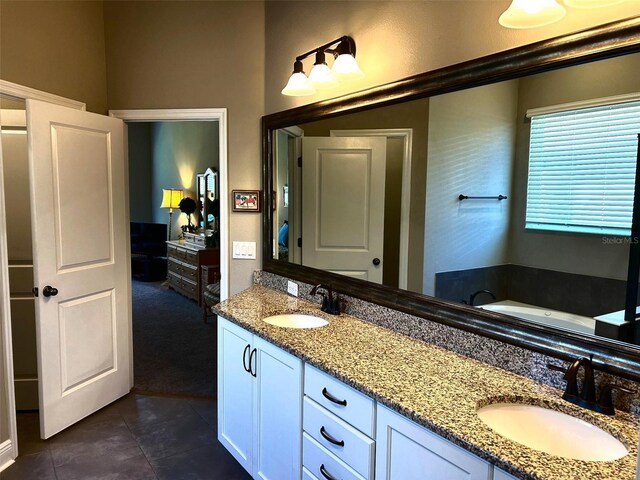 full bath with double vanity, a sink, a bath, and tile patterned floors