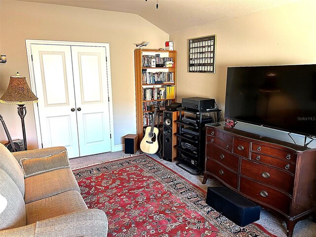 carpeted living room with lofted ceiling