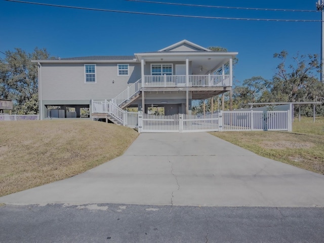 view of front of home with a carport, covered porch, and a front lawn