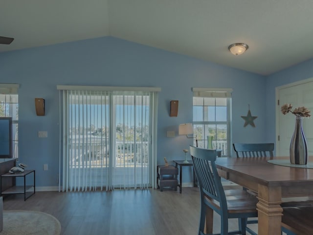 dining area featuring hardwood / wood-style floors and vaulted ceiling