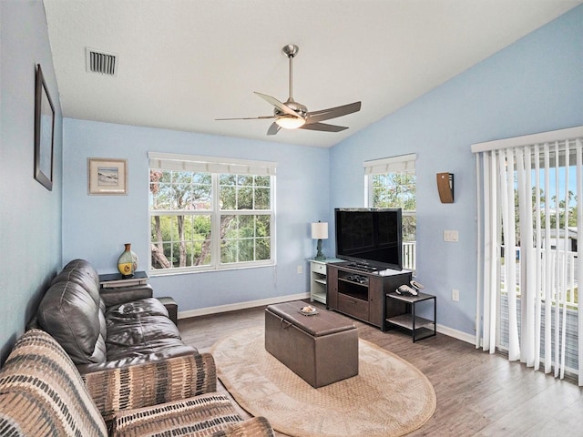 living room featuring ceiling fan, wood-type flooring, and vaulted ceiling