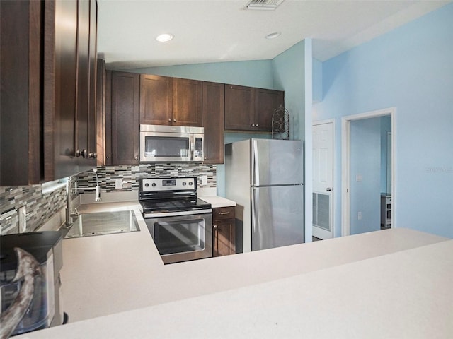 kitchen featuring dark brown cabinetry, sink, stainless steel appliances, tasteful backsplash, and lofted ceiling