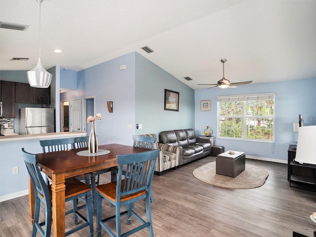 dining room with dark wood-type flooring, ceiling fan, and lofted ceiling