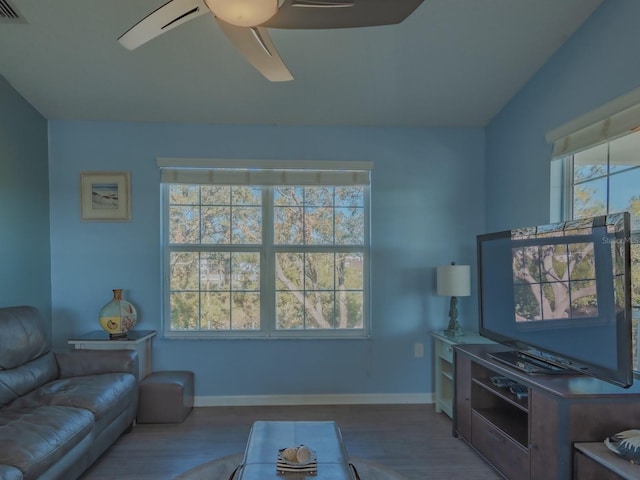 living room with ceiling fan, wood-type flooring, and a wealth of natural light