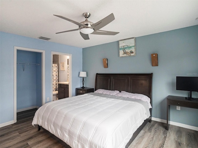 bedroom featuring a walk in closet, ceiling fan, hardwood / wood-style floors, connected bathroom, and a closet