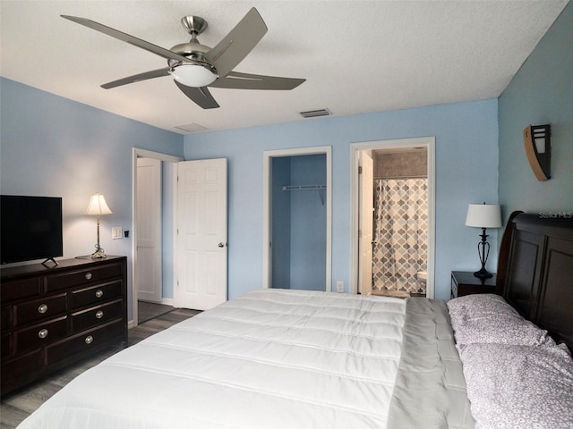 bedroom featuring a walk in closet, ensuite bathroom, ceiling fan, light hardwood / wood-style floors, and a closet