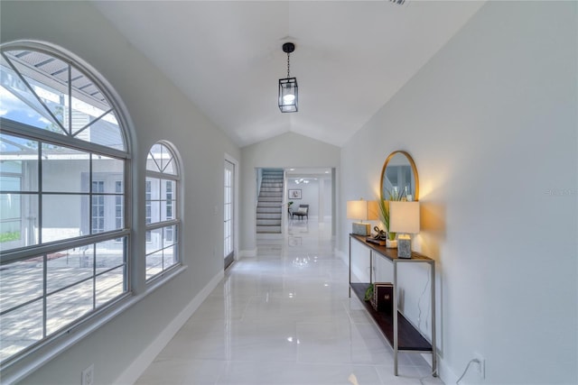 hallway featuring light tile patterned floors and vaulted ceiling