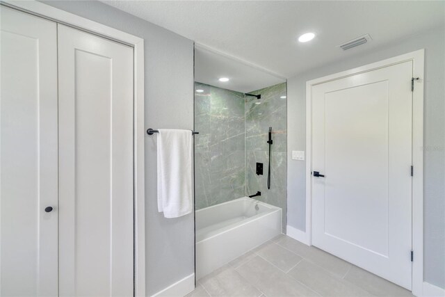 bathroom with tile patterned floors and tiled shower / bath combo