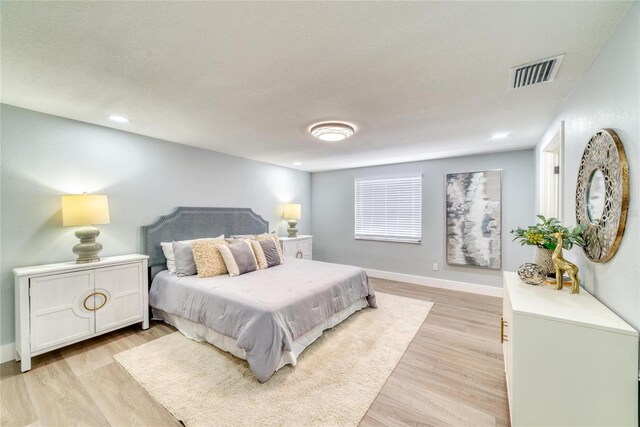 bedroom with light wood-type flooring and a textured ceiling