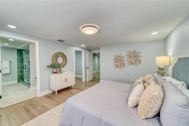 bedroom featuring a textured ceiling, ensuite bathroom, and hardwood / wood-style flooring