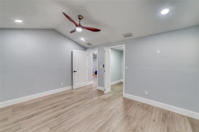 spare room featuring lofted ceiling, ceiling fan, and light wood-type flooring