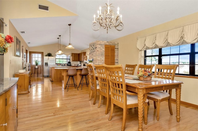 dining space featuring lofted ceiling, light wood-style floors, baseboards, and visible vents