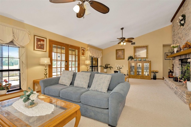 carpeted living room with lofted ceiling, ceiling fan, a fireplace, visible vents, and french doors