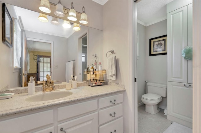 bathroom with vanity, ornamental molding, tile patterned flooring, and toilet