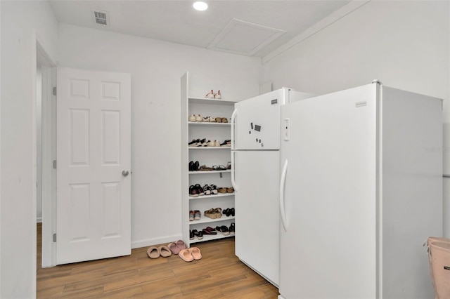 kitchen with freestanding refrigerator, visible vents, open shelves, and wood finished floors