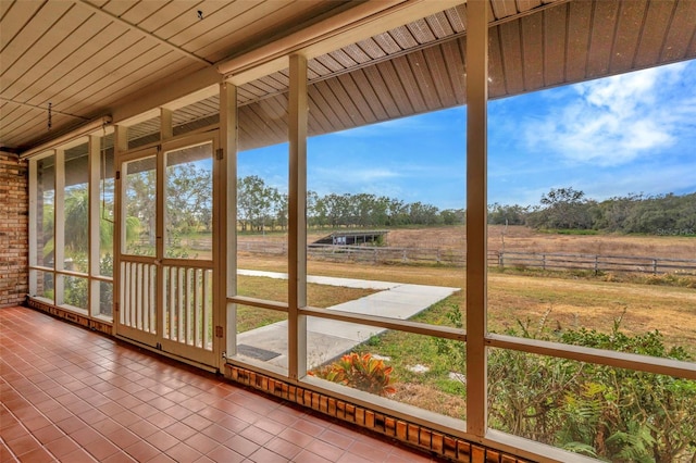 unfurnished sunroom featuring a rural view and wooden ceiling