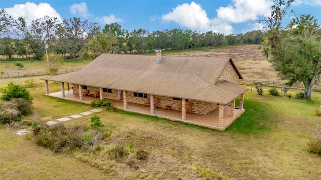 back of house featuring a shingled roof, a lawn, a patio area, and fence