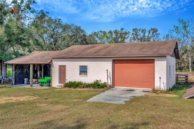 exterior space with a garage, an outdoor structure, and a front yard