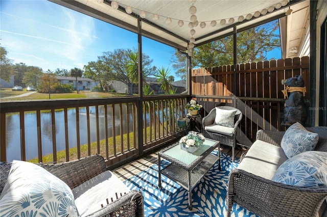 sunroom / solarium featuring an outdoor living space, plenty of natural light, and a water view
