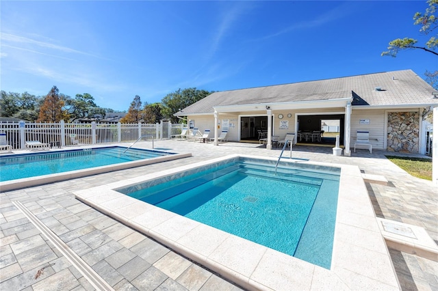 community pool with fence and a patio