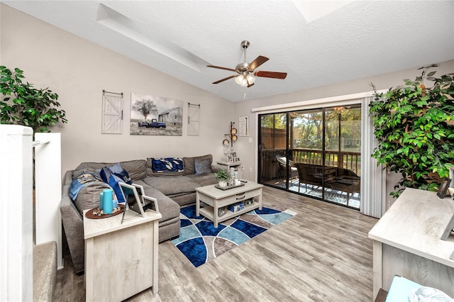 living room with a textured ceiling, ceiling fan, lofted ceiling, and wood finished floors