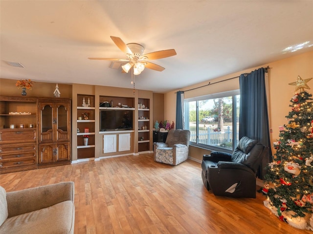 living room with ceiling fan and light hardwood / wood-style flooring