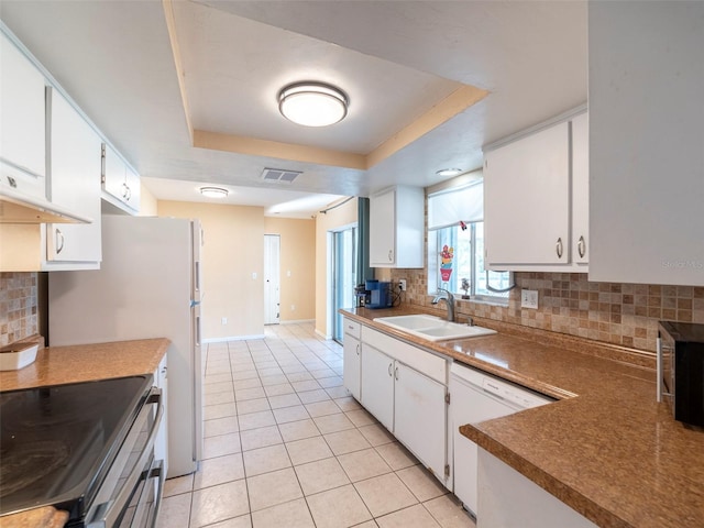 kitchen with sink, stainless steel appliances, a tray ceiling, decorative backsplash, and white cabinets