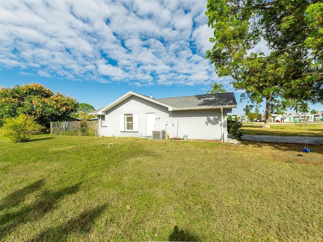 back of property featuring a lawn and central AC unit