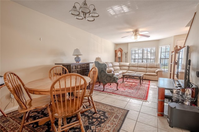 tiled dining room featuring ceiling fan with notable chandelier