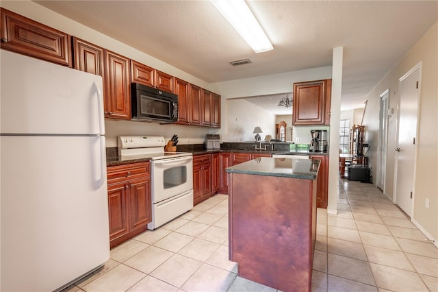 kitchen with sink, a kitchen island, a textured ceiling, white appliances, and light tile patterned floors