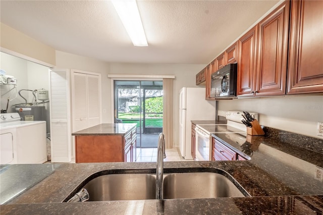 kitchen with sink, dark stone countertops, a textured ceiling, white appliances, and washer and dryer