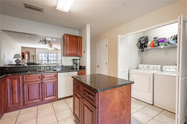 kitchen featuring ceiling fan, dishwasher, sink, washing machine and dryer, and a kitchen island