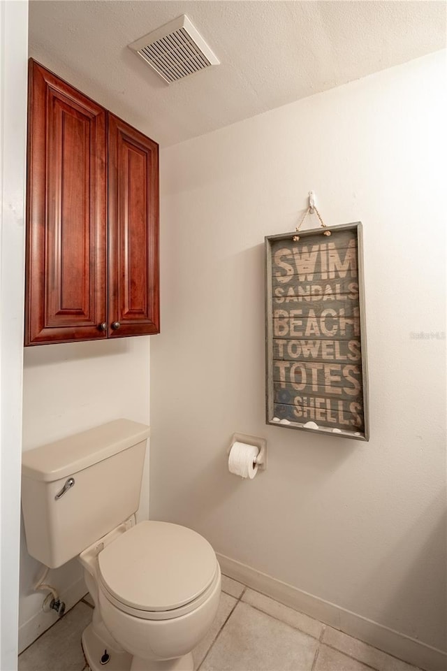 bathroom with tile patterned flooring, a textured ceiling, and toilet