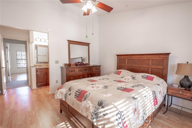 bedroom with ensuite bath, ceiling fan, and light hardwood / wood-style flooring