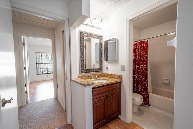 full bathroom with wood-type flooring, a textured ceiling, toilet, vanity, and shower / tub combo